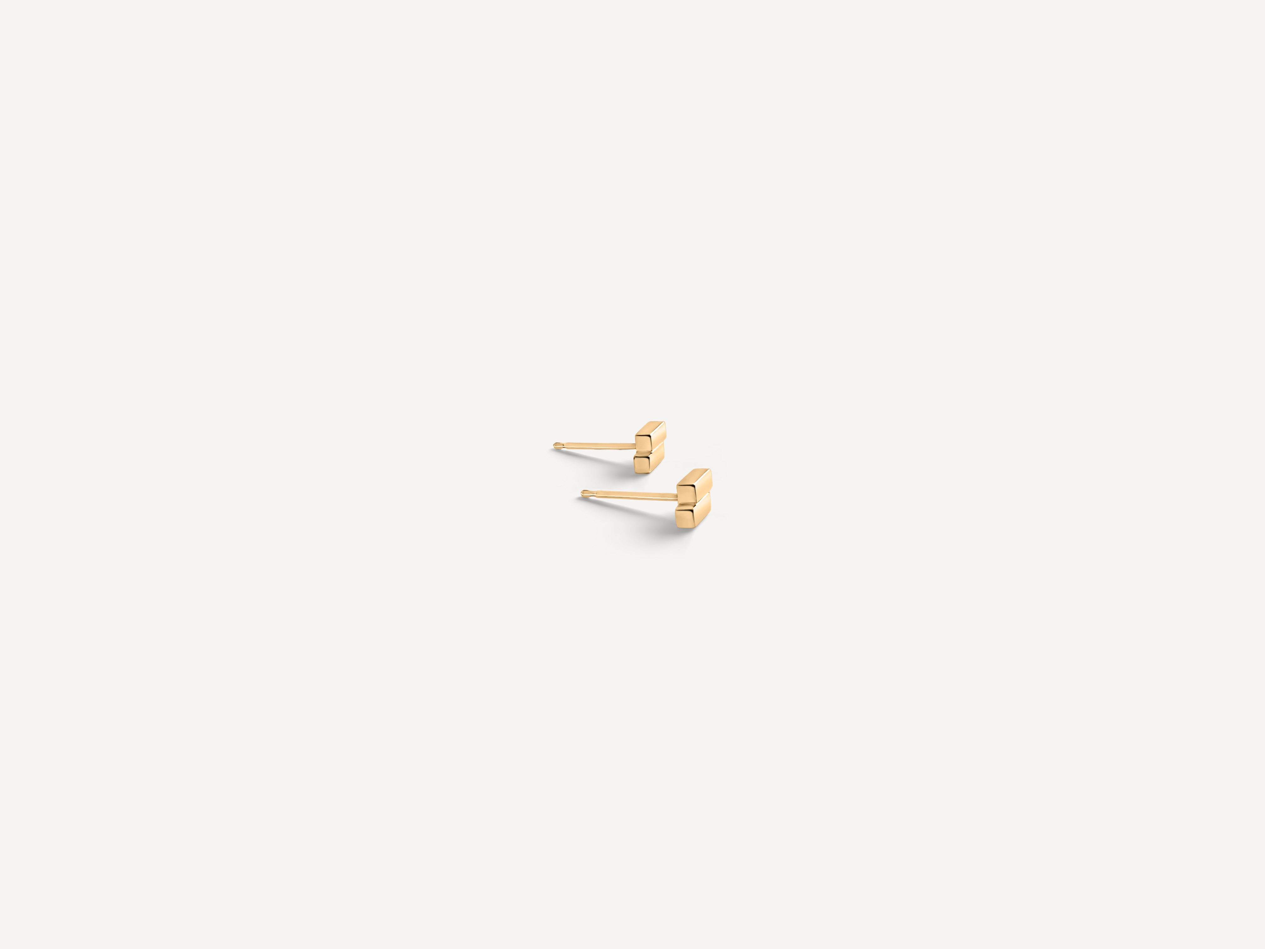 Minimal solid gold bar studs shown from side angle, featuring architectural rectangular design for modern minimalist style.