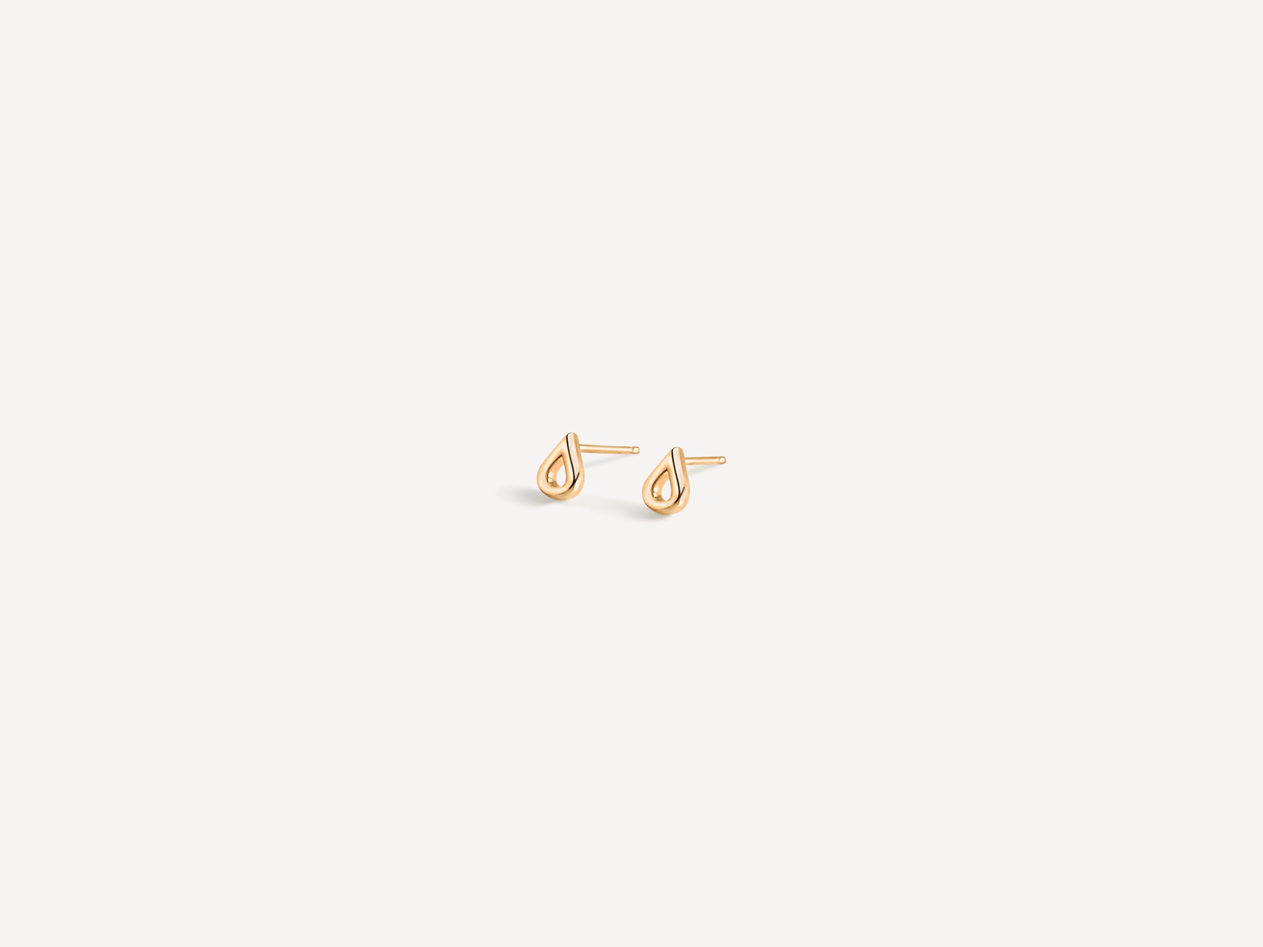 Solid gold teardrop studs from side angle highlighting dimensional design and smooth curved silhouette