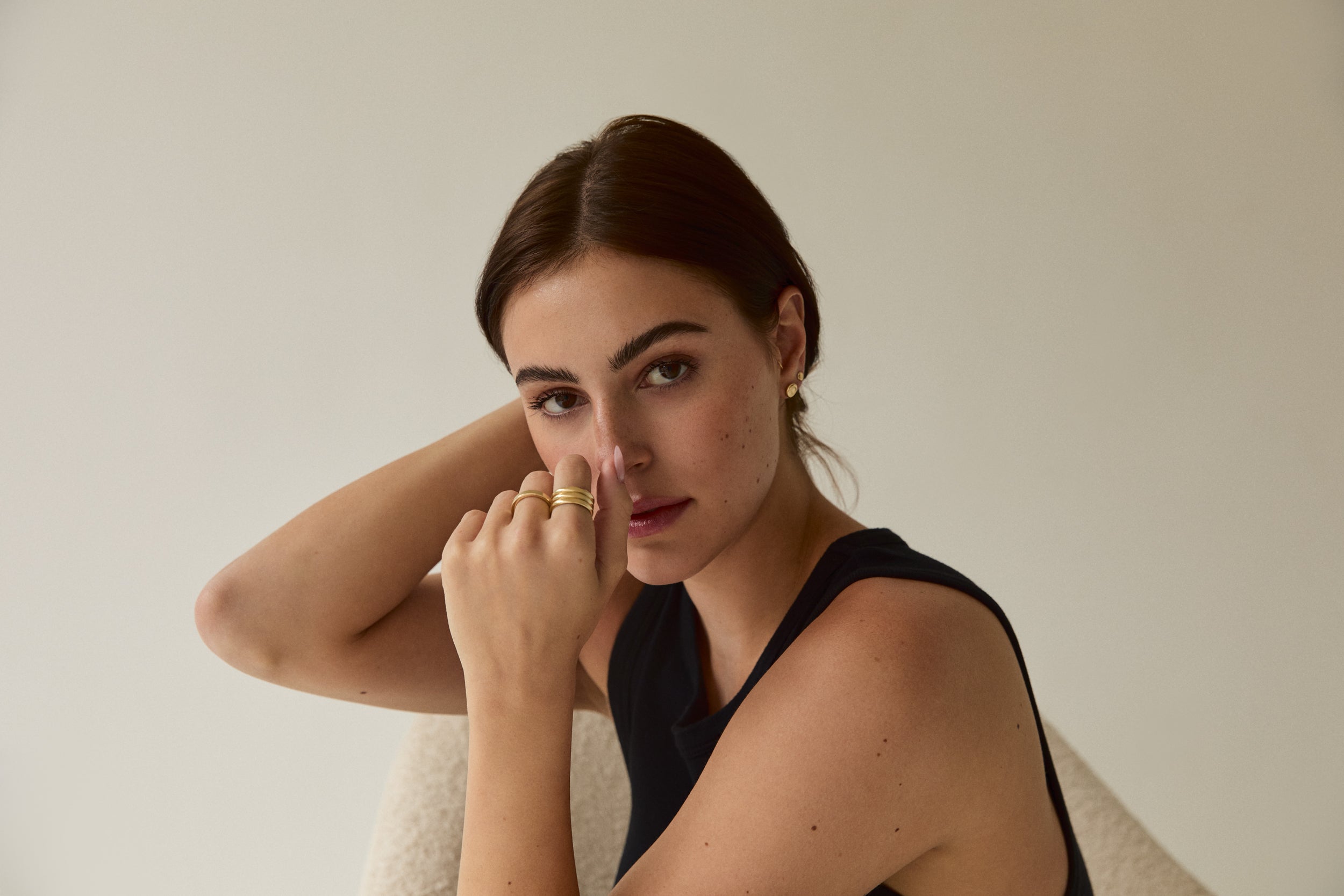 Model wearing a gold triple-band ring by Sheena Marshall Jewelry, showcasing a minimalist and timeless design
