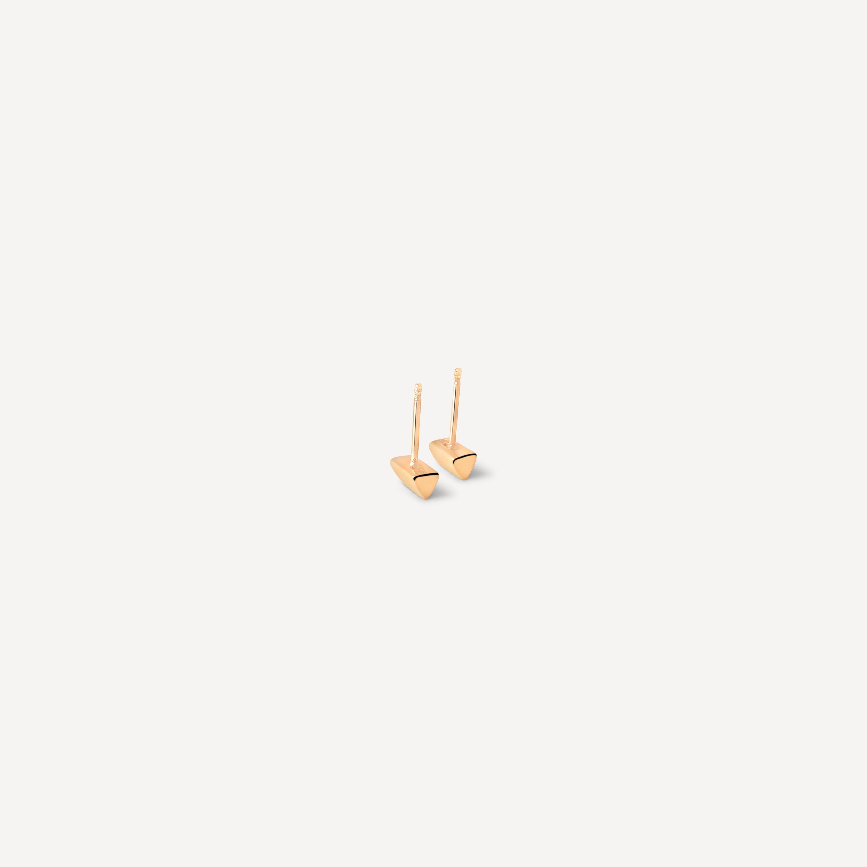 Detailed view of minimal knife edge studs in solid gold, showcasing the precise geometric cutting that defines these modern earrings
