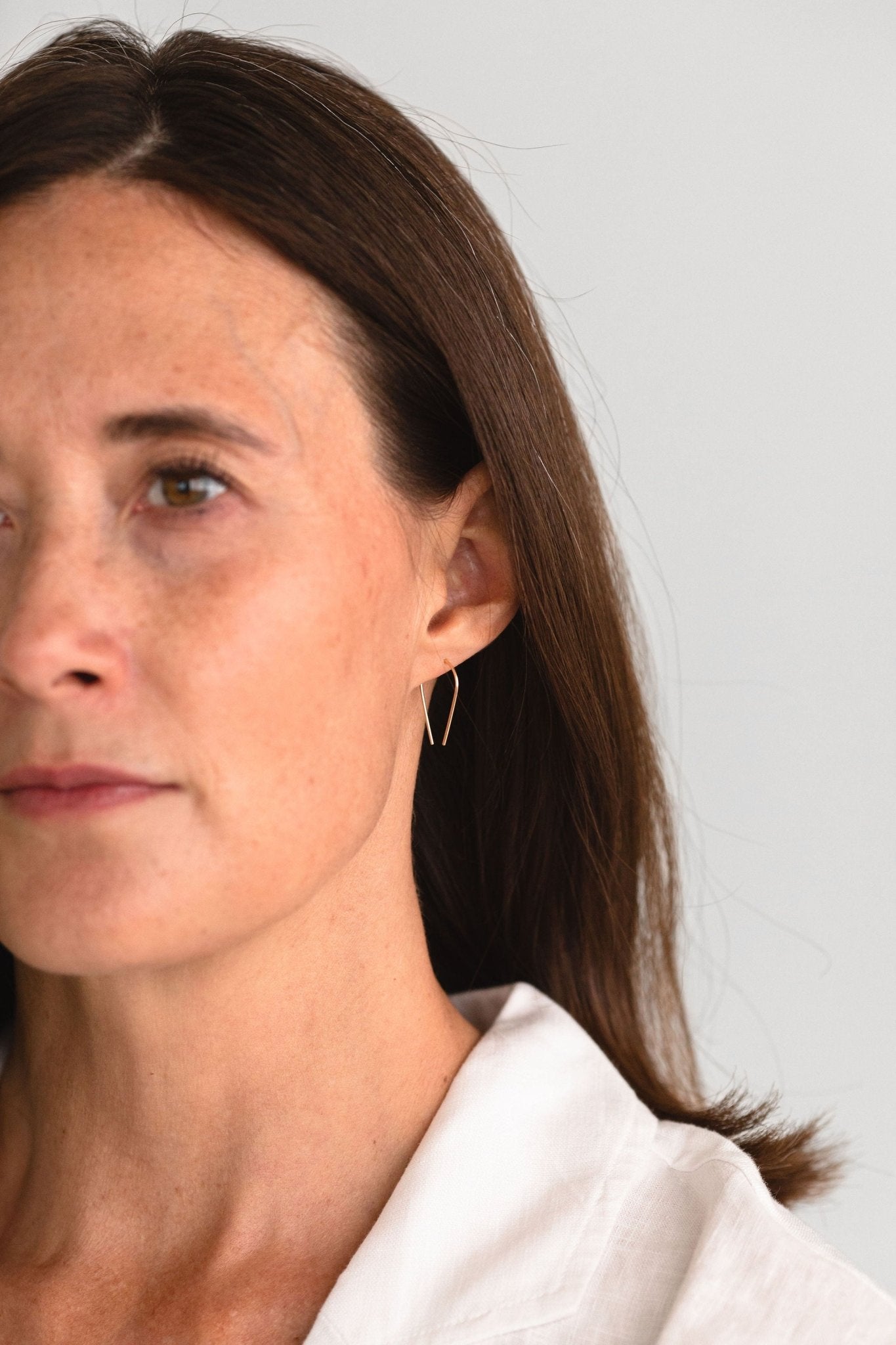 Woman wearing Sterling Silver Palmer Arch Threader Earrings in Denver, perfect for a minimalist, modern style.
