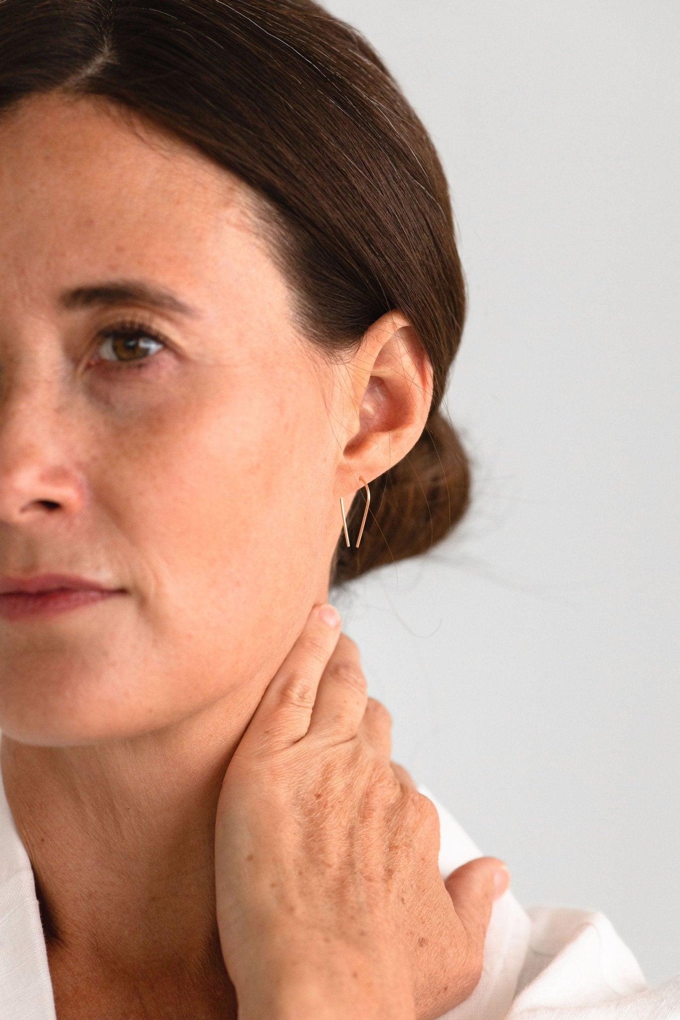terling Silver Palmer Arch Threader Earrings worn, highlighting their graceful arc and elevated and casual handmade craftsmanship.