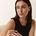 Model wearing delicate 14k gold jewelry with a minimal background.