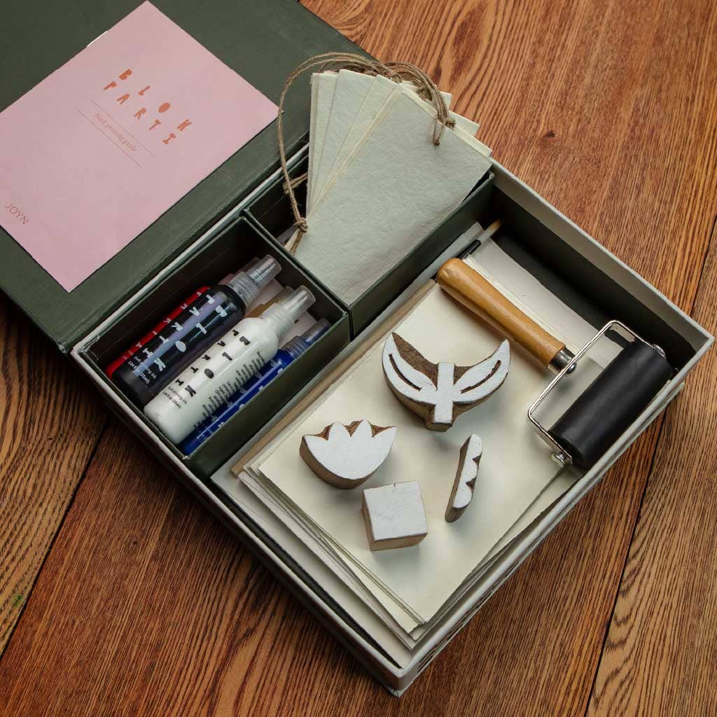 Set of stamping tools and ink pad in a box on a wooden surface