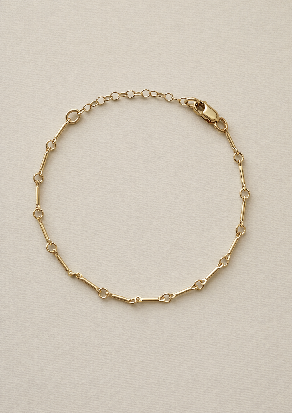 Gold fill bone link bracelet on a beige background with 1 inch extender