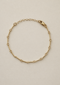 Gold fill bone link bracelet on a beige background with 1 inch extender