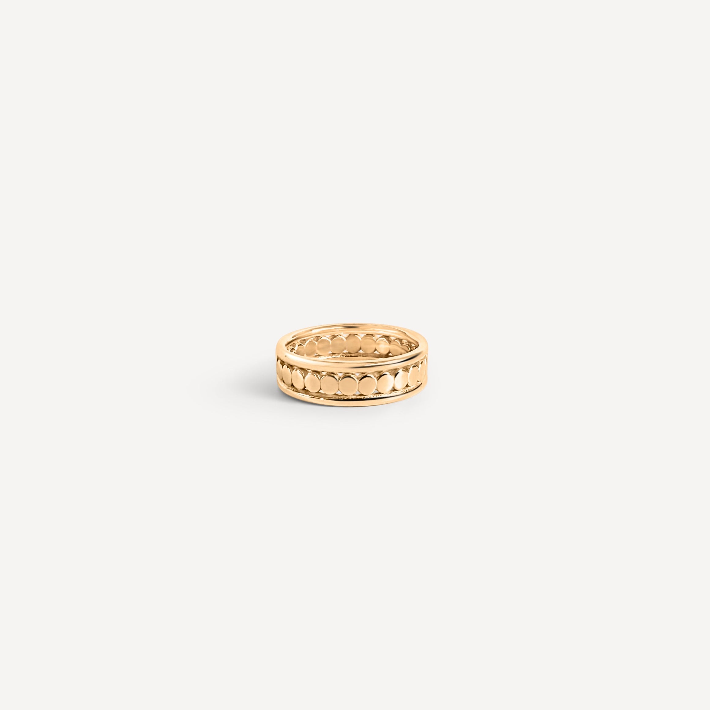 Gold ring on a light beige background