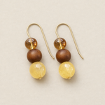 Pair of earrings with wooden and yellow beads on a beige background