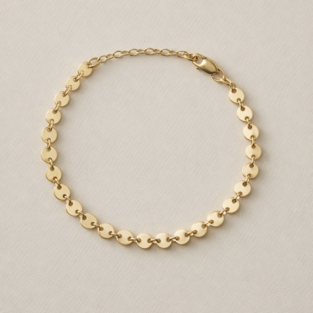 Confettie Disc Gold chain bracelet on a beige background with one inch extender