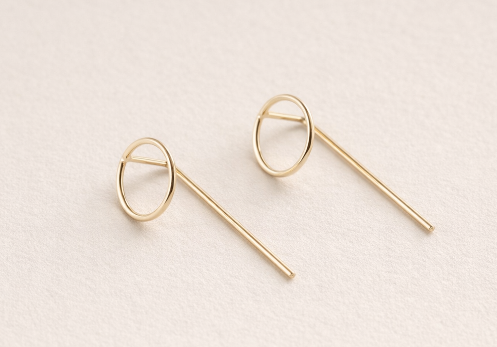 Pair of gold hoop earrings on a light beige background