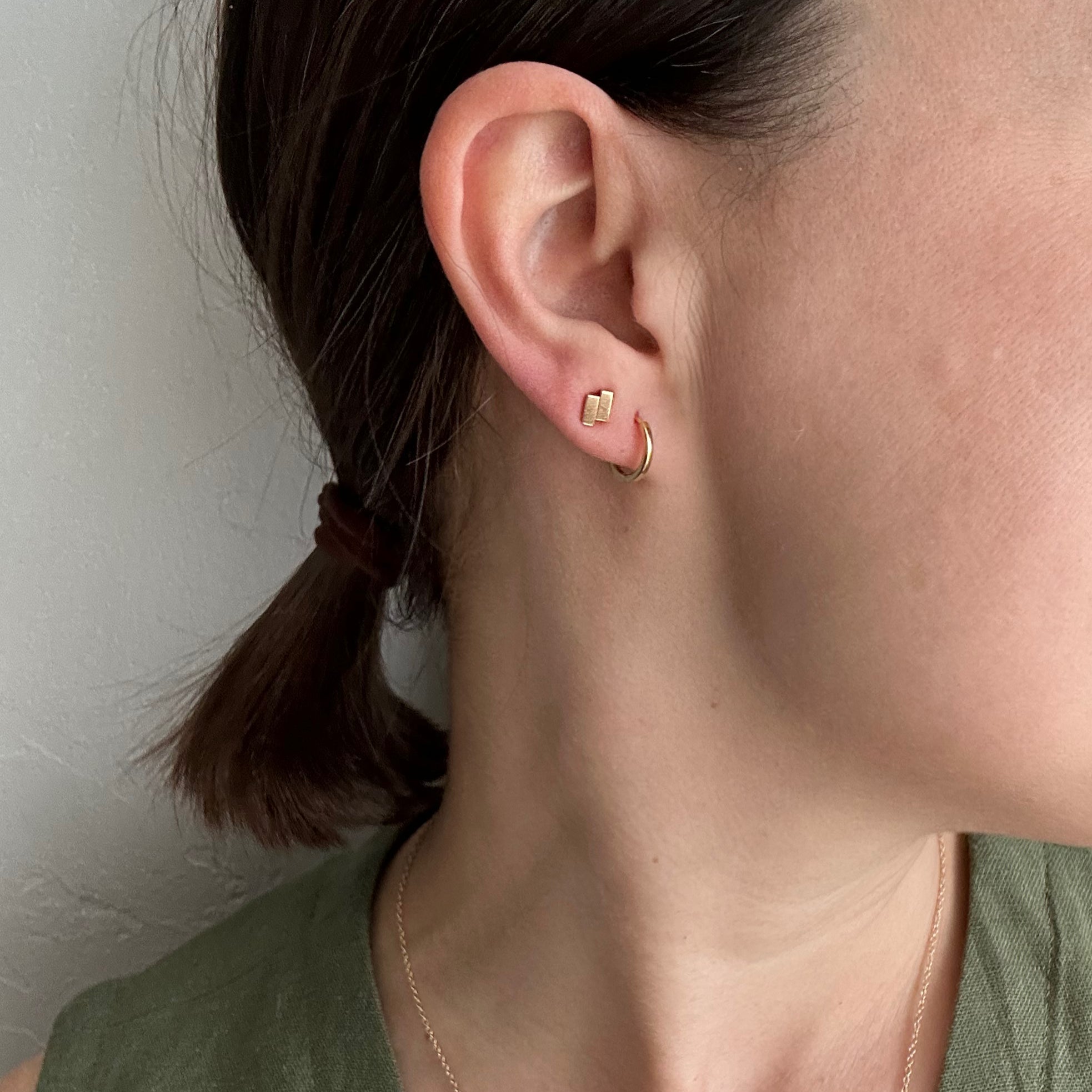 perfectly imperfect jewelry, non traditional fine jewelry geometric studs in solid recycled 14k gold on model