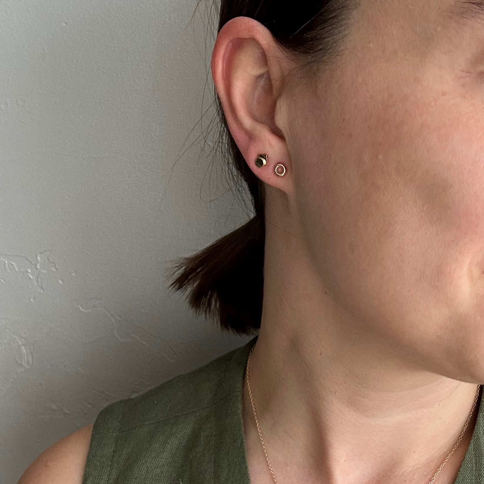 perfectly imperfect jewelry, non traditional fine jewelry geometic studs in solid recycled 14k gold on model showcasing stacked gold earrings