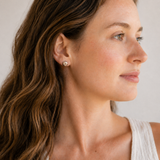 Woman wearing a white sleeveless top with a neutral background