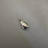 A small polished silver teardrop-shaped pendant or charm with a short loop at the top, placed on a textured light gray surface.