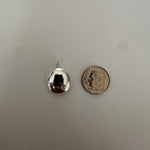 A small silver teardrop-shaped pendant with a reflective surface, shown next to a US quarter coin for scale on a light gray textured background.
