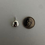 A small silver earring with a butterfly back is shown next to a US dime for scale, on a light gray textured background.