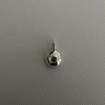 A small silver circular stud earring with a central clear gemstone and a top prong setting, shown on a textured light gray background.