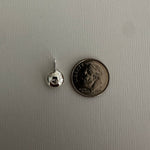 A small silver jewelry component, likely a bead or charm with a loop, shown next to a U.S.