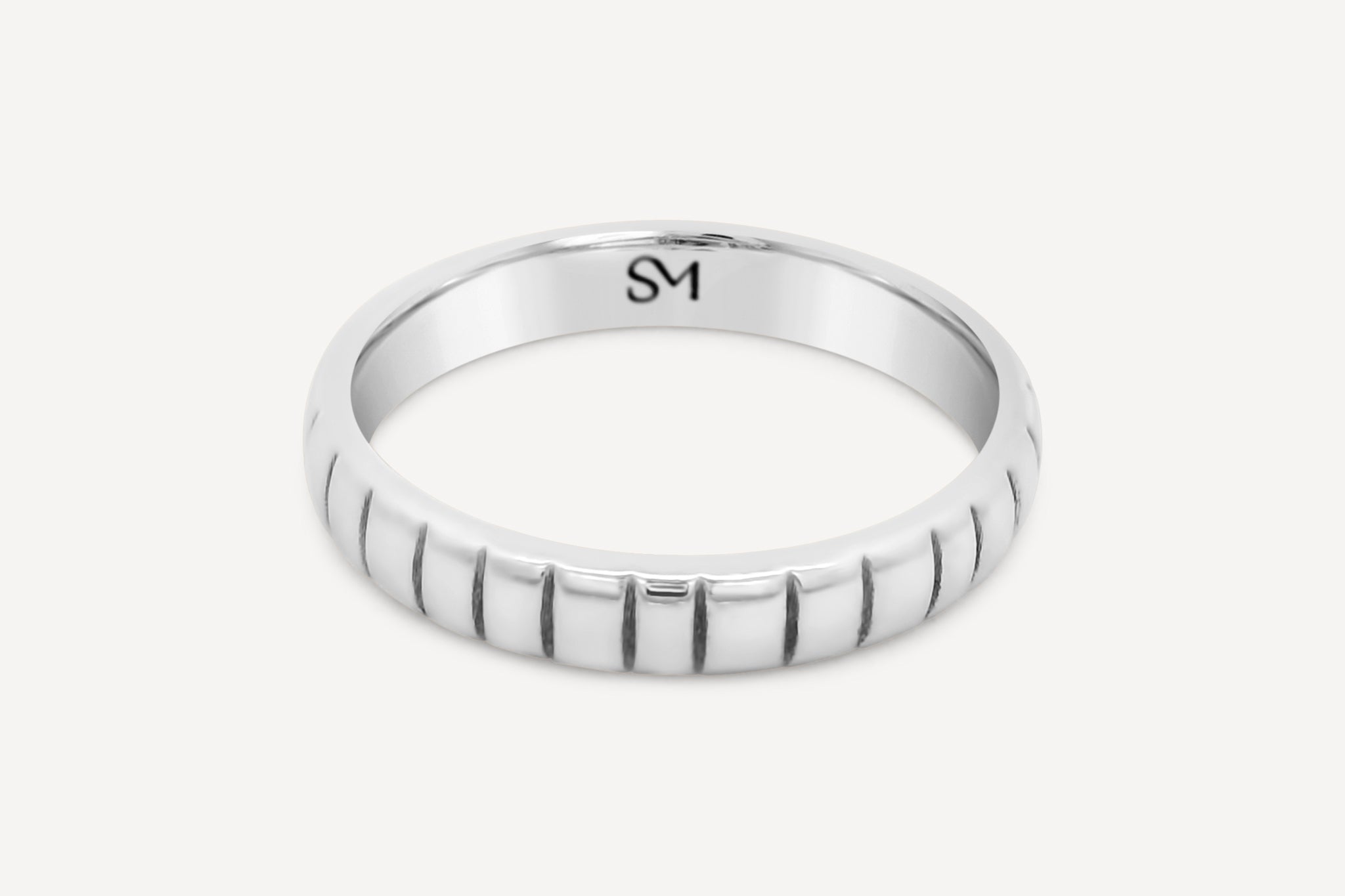 Sterling silver Notch Band flat lay showcasing its sleek profile and elegant design.