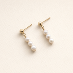 Pair of pearl earrings on a light beige background