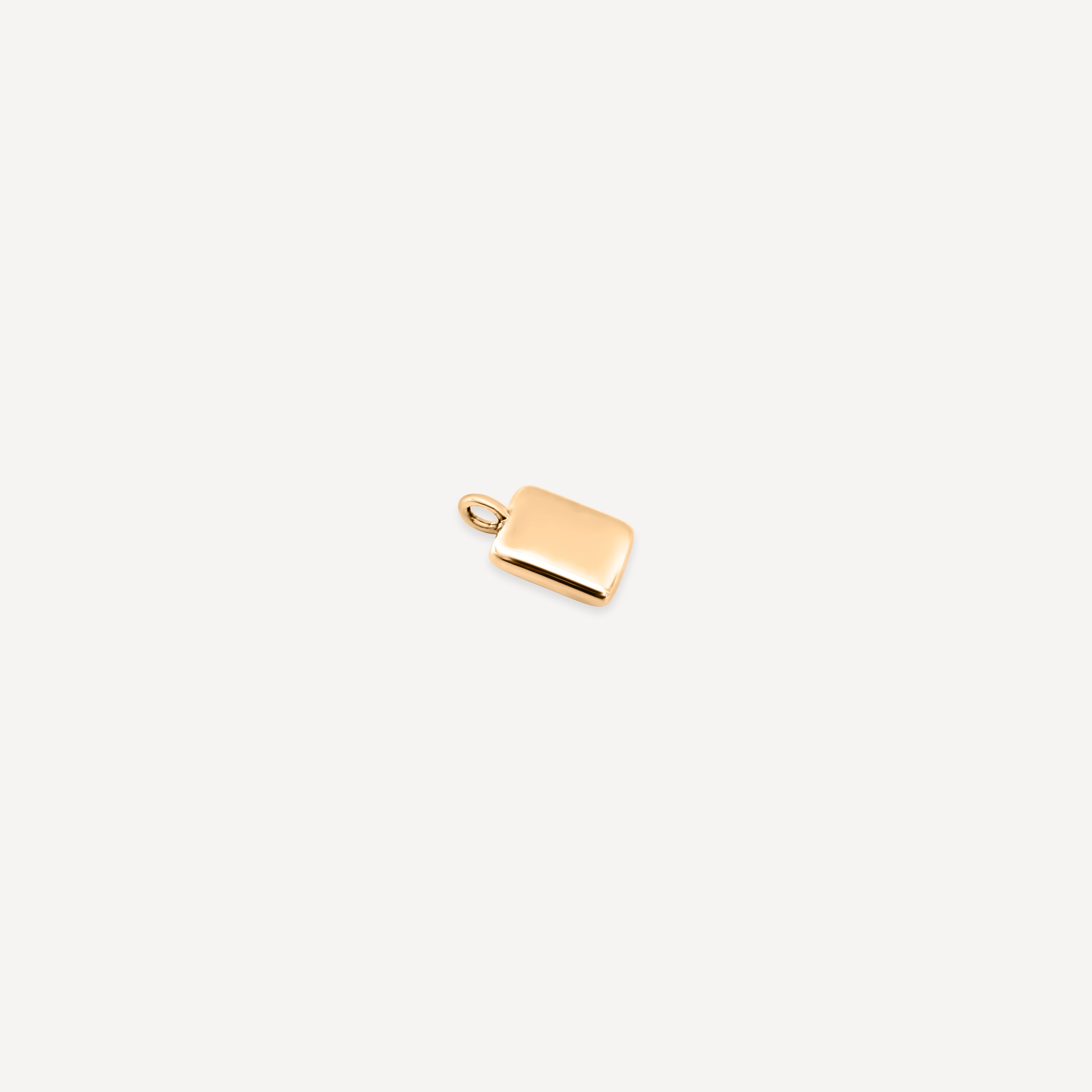 Close-up of just the gold rectangular pendant charm with a small loop at the top for attachment.