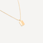 Full view of the gold chain necklace with the rectangular pendant displayed centrally against a white background.