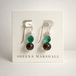 Pair of 14k gold fill glass and pearl earrings on a Sheena Marshall branded card against a light gray background