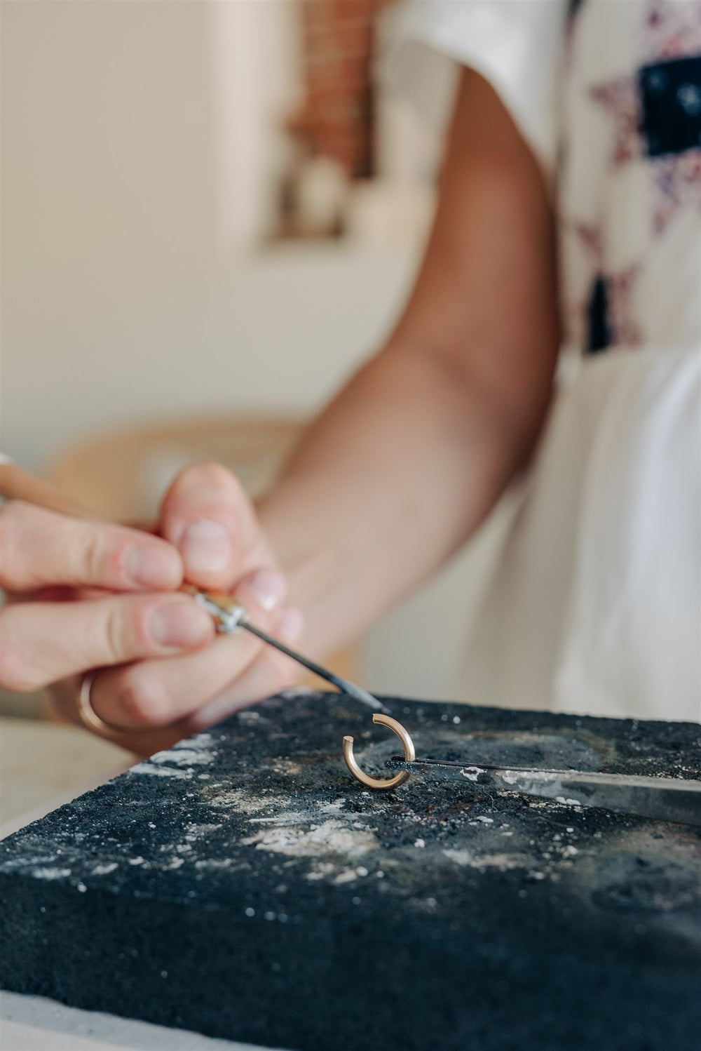 Hands working on a circular jewelry component