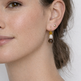 Close-up of a woman wearing earrings with a neutral background