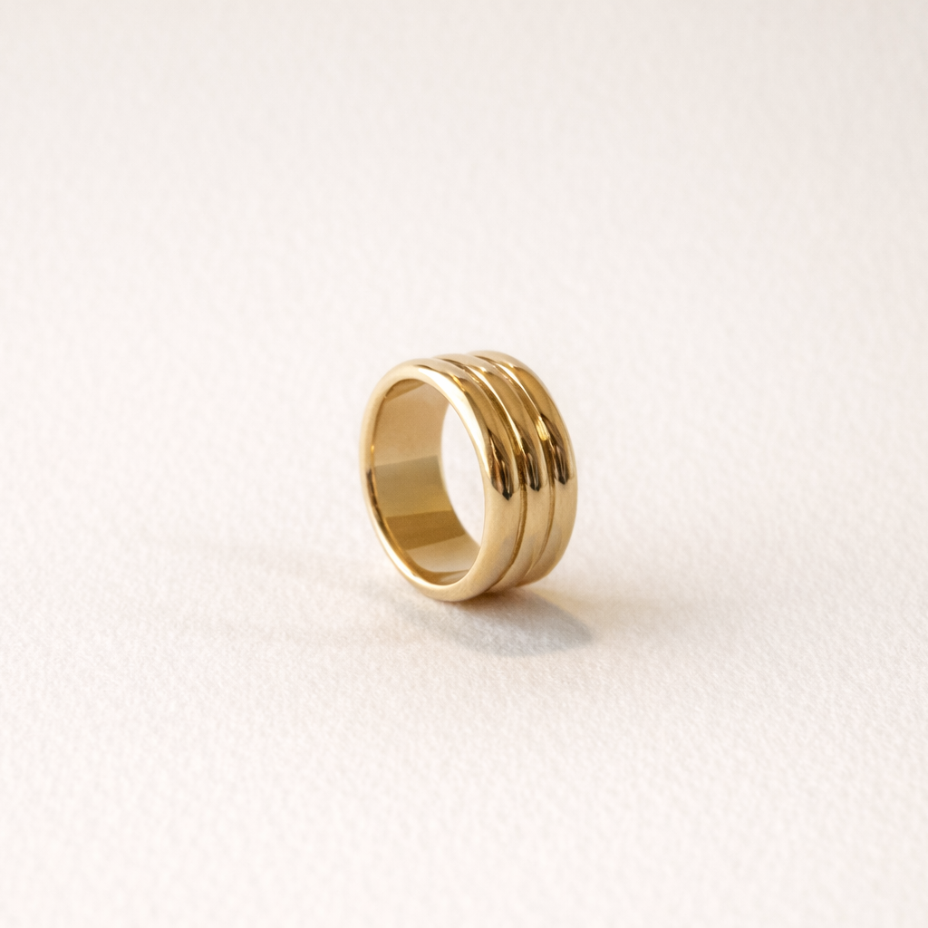 Gold ring on a light beige background