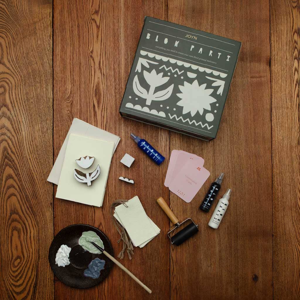 Crafting supplies including a book titled 'Block Parties' on a wooden surface.