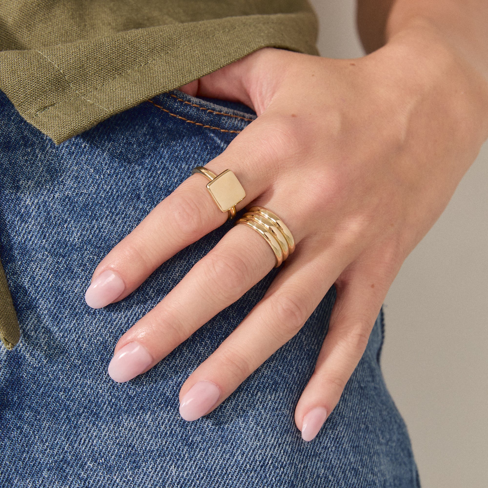 Brass square ring worn on a hand, showcasing its minimalist design paired with casual denim.