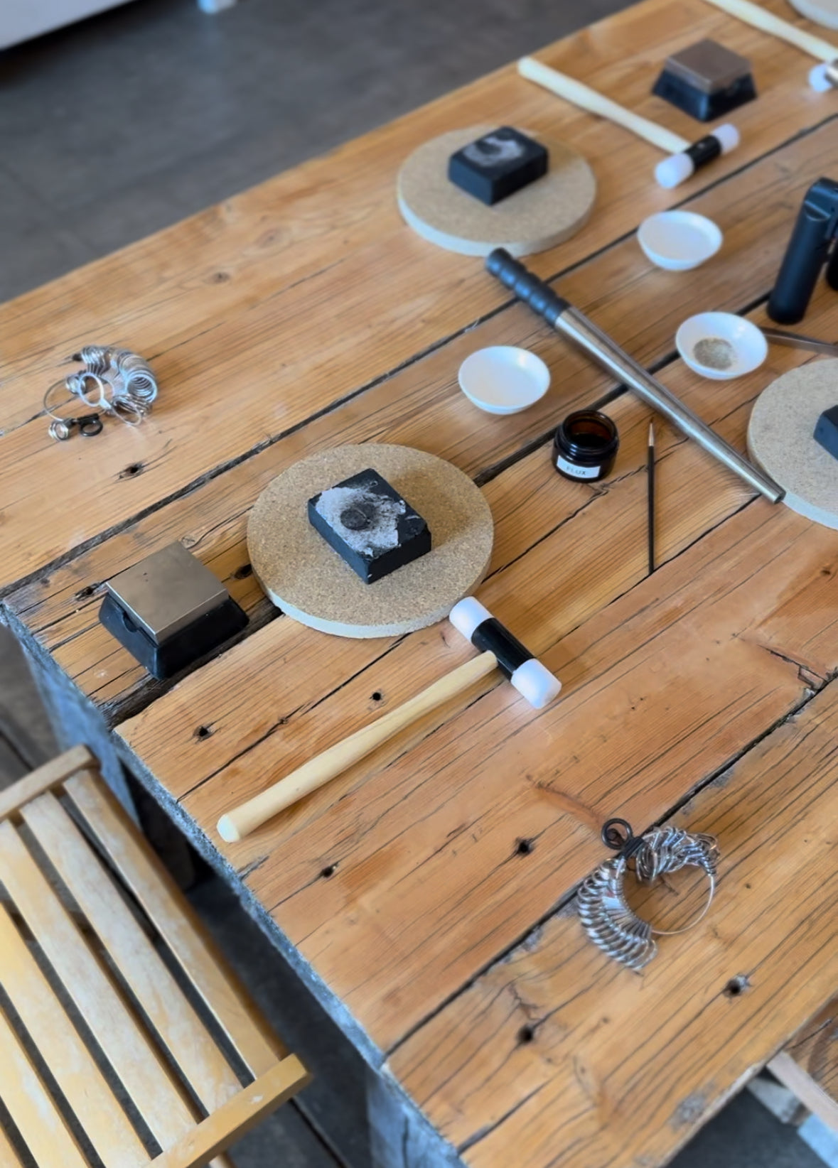 Close-up of hands shaping a silver ring during a jewelry-making class.