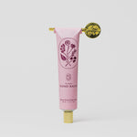 Tallow Pink hand balm tube with floral design and gold cap on a white background