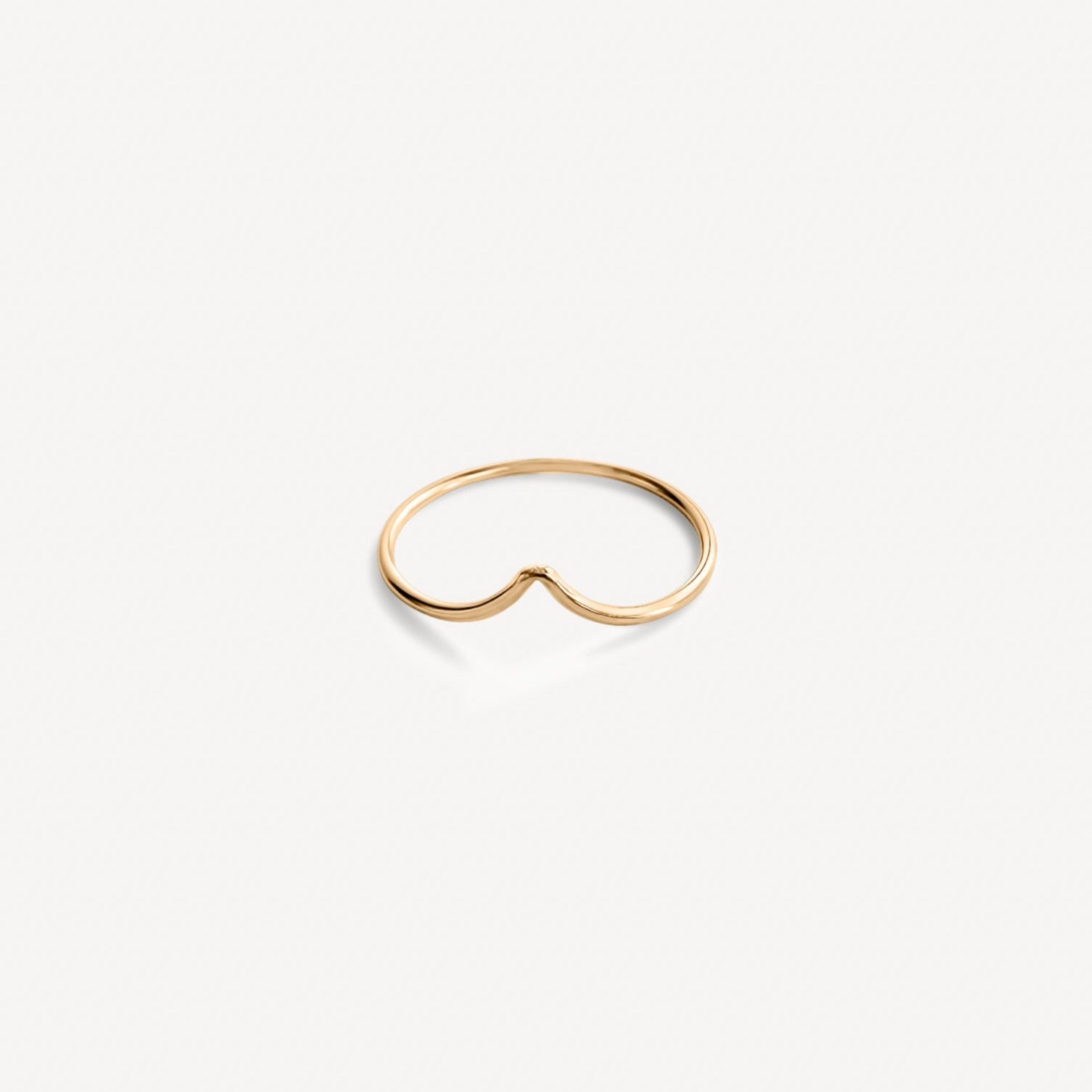 Gold-filled Emilie Arch Ring flat lay against neutral background.