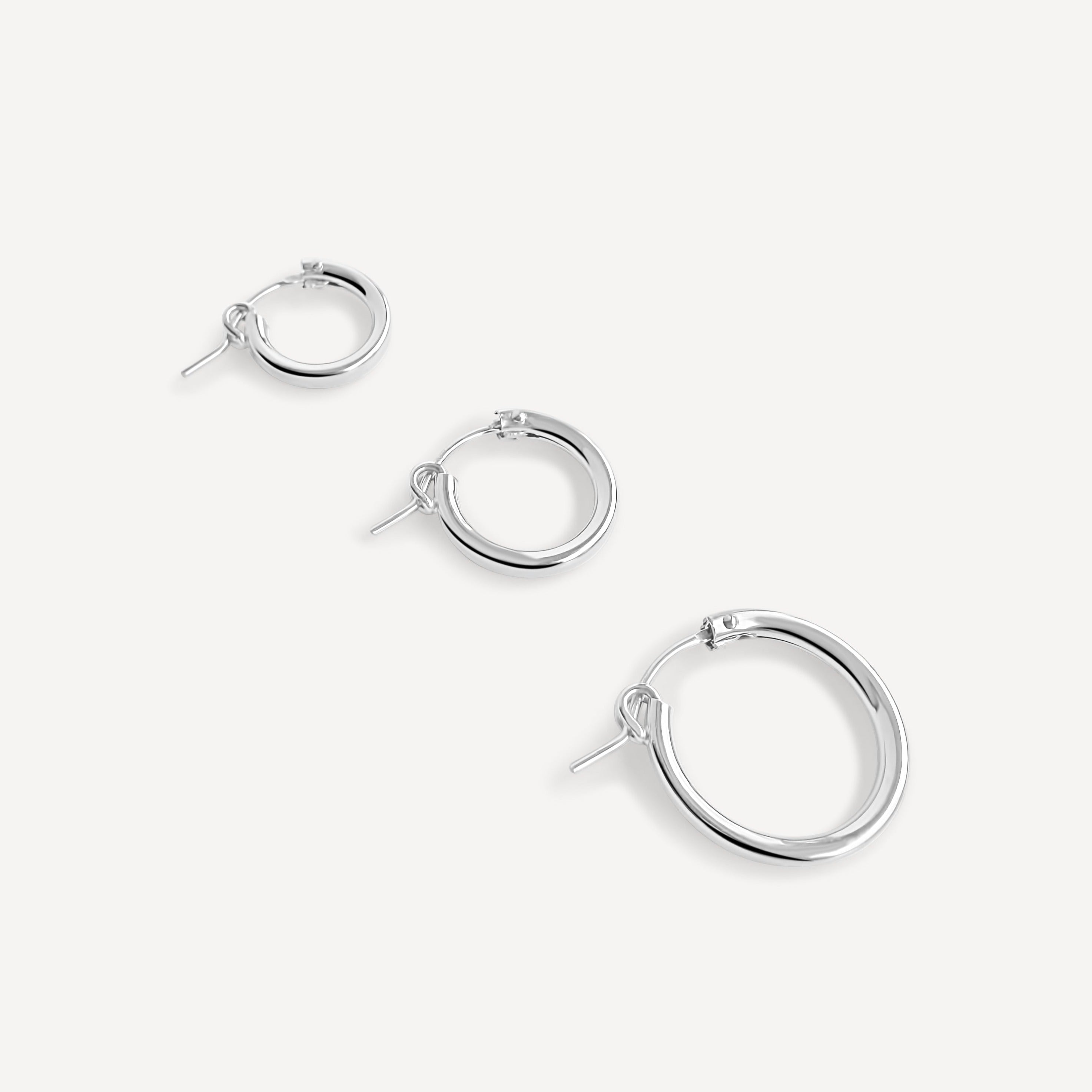 Three sizes of sterling silver click hoop earrings (19mm, 15mm, and 13mm) displayed flat.