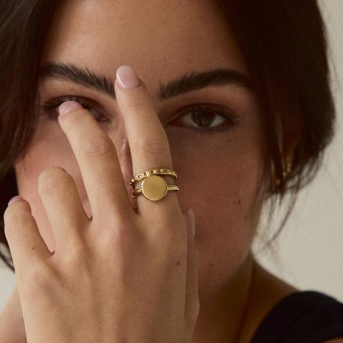 Model wearing the Forma Coin Ring, highlighting its timeless and minimal solid gold style.