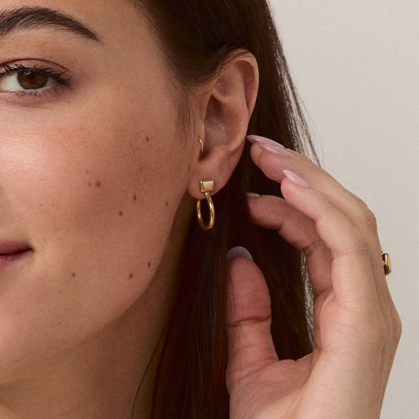 Model wearing Forma Rectangle Hoops in 14k solid gold, emphasizing their understated elegance and modern design.