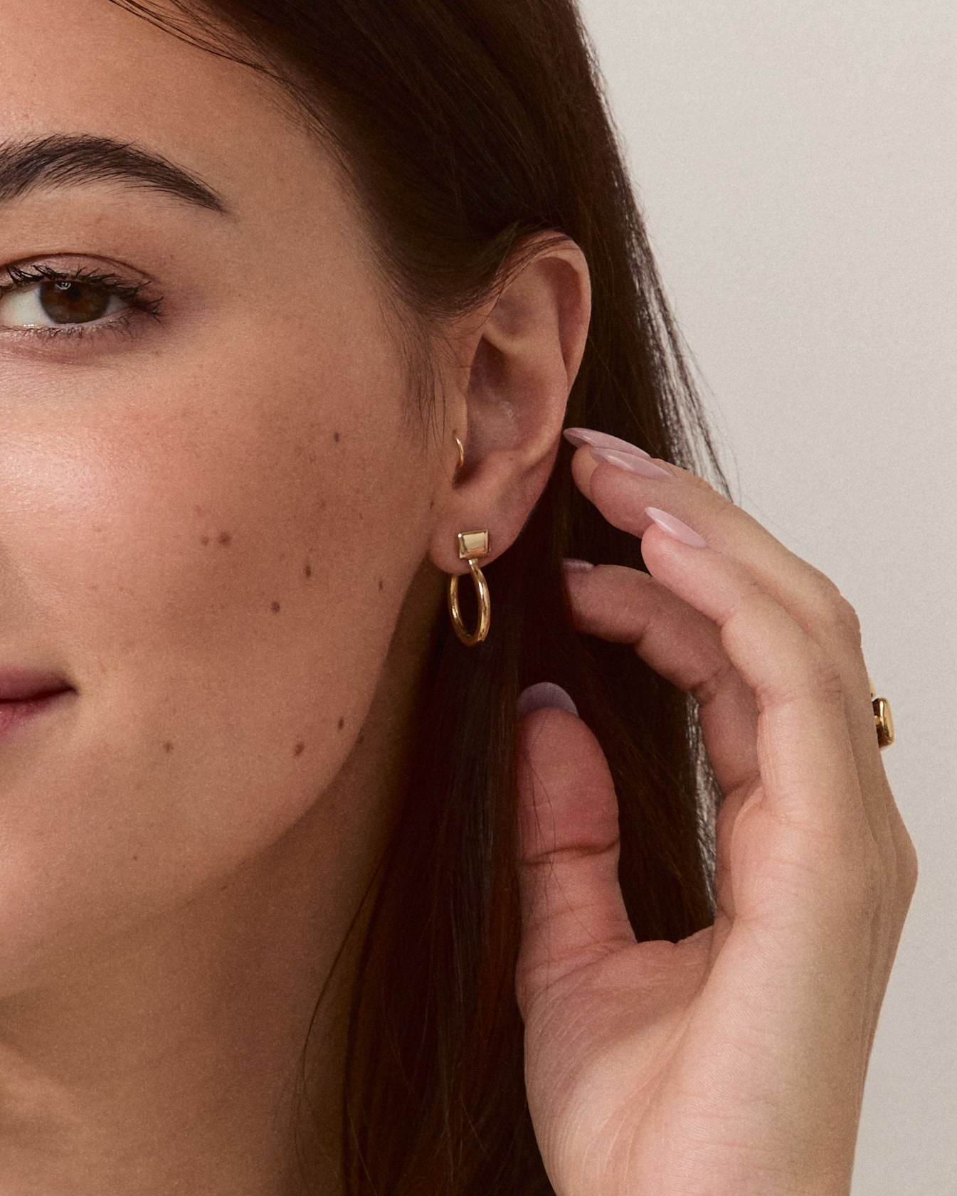 Model wearing Forma Rectangle Hoops in 14k solid gold, emphasizing their understated elegance and modern design.