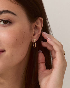 Model wearing Forma Rectangle Hoops in 14k solid gold, emphasizing their understated elegance and modern design.