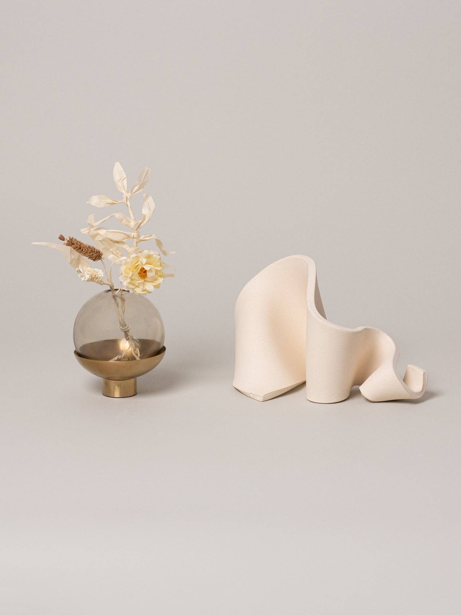 Furl Art Object, Bone displayed beside flowers