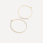 Pair of 1.5-inch gold fill essential hoop earrings on a white background.