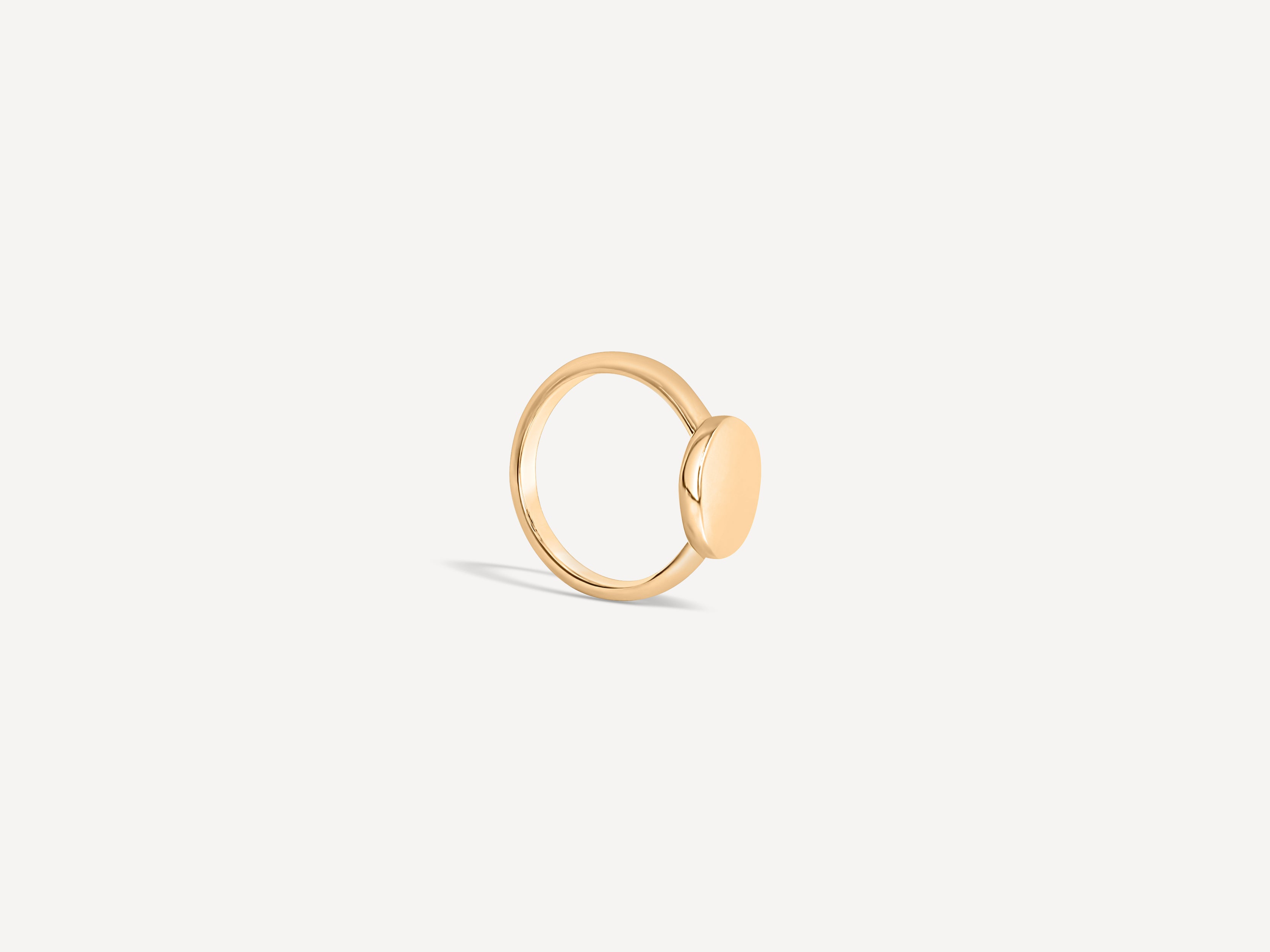 Side view of the solid gold signet ring, highlighting its smooth band and polished round face.