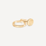 A stack of gold rings, including the signet ring, arranged on a neutral background to showcase variety.