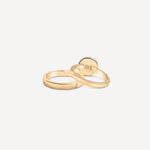 A stack of gold rings, including the signet ring, arranged on a neutral background to showcase variety.