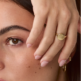 Solid gold signet coin ring styled on a model’s hand, paired with other rings for an elegant look, 14k solid gold