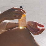 High Noon Body Oil, Palo Santo: Travel Size 2 fl oz dispensed into a hand