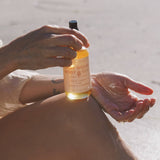 High Noon Body Oil, Palo Santo: Travel Size 2 fl oz dispensed into a hand