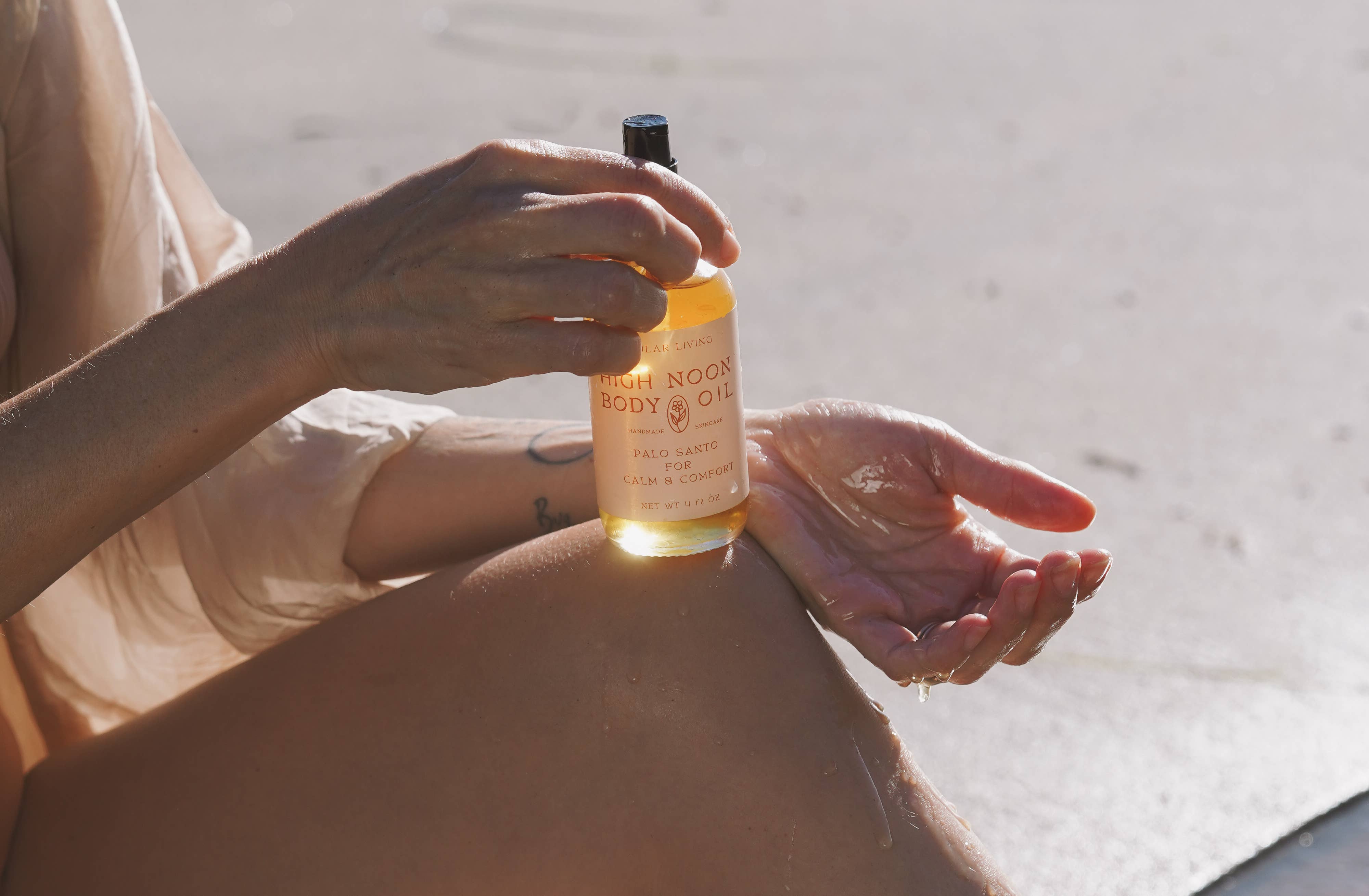 High Noon Body Oil, Palo Santo: Travel Size 2 fl oz dispensed into a hand