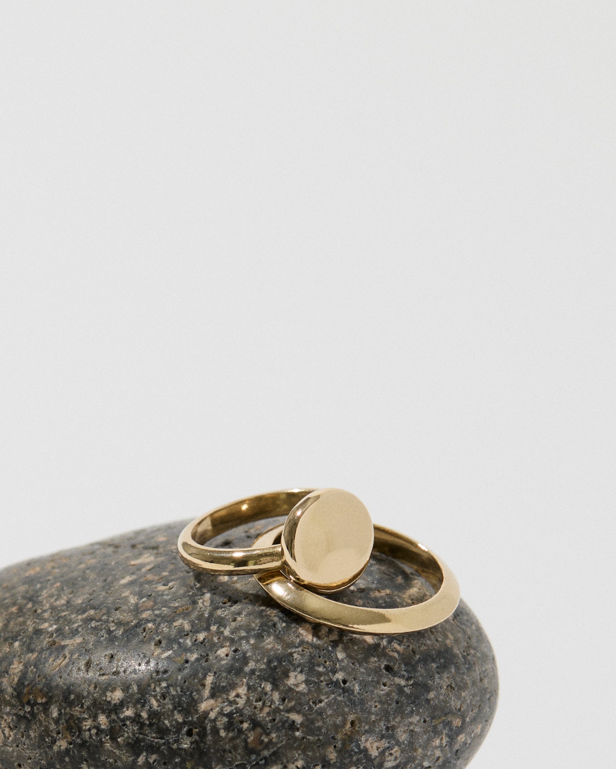 Knife Edge Ring, Solid 14k Gold displayed with other rings on a stone